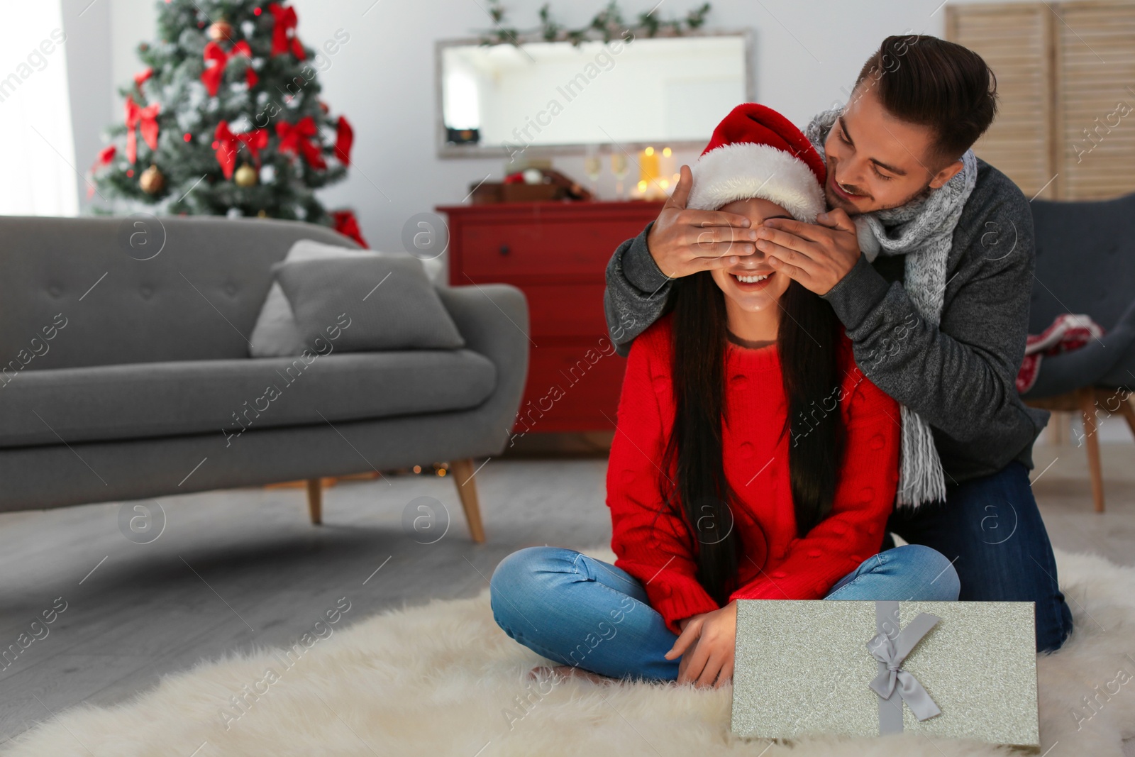 Photo of Happy young couple celebrating Christmas at home