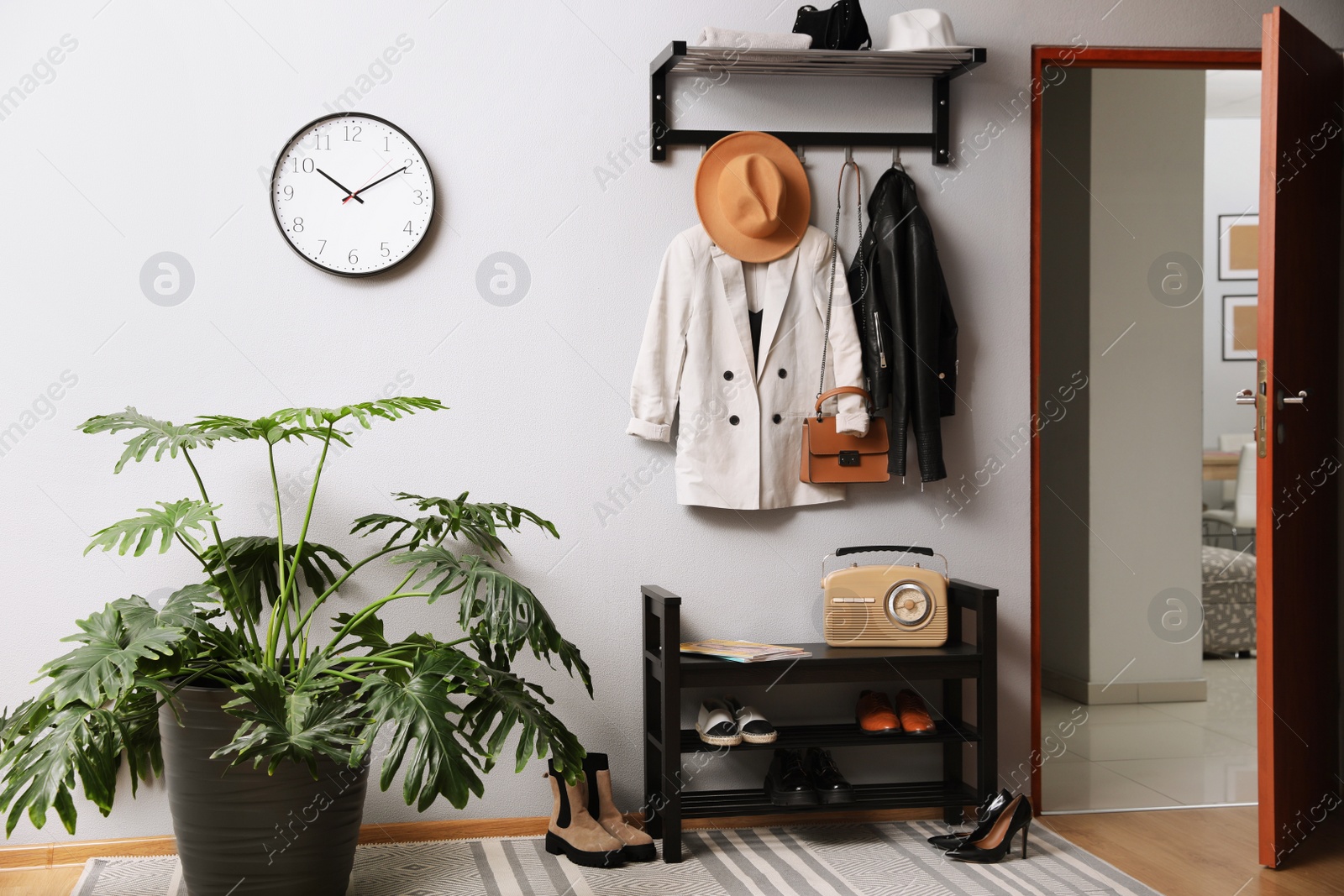 Photo of Hallway interior with stylish furniture, clothes and accessories