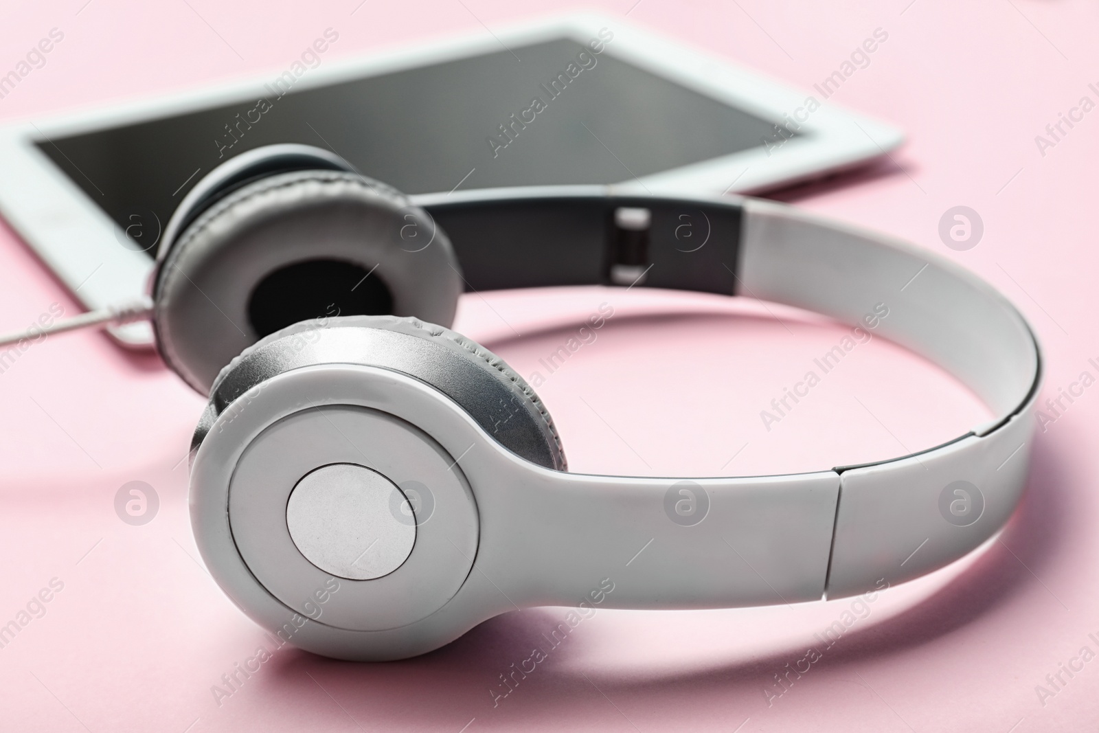 Photo of Stylish headphones and tablet on color background