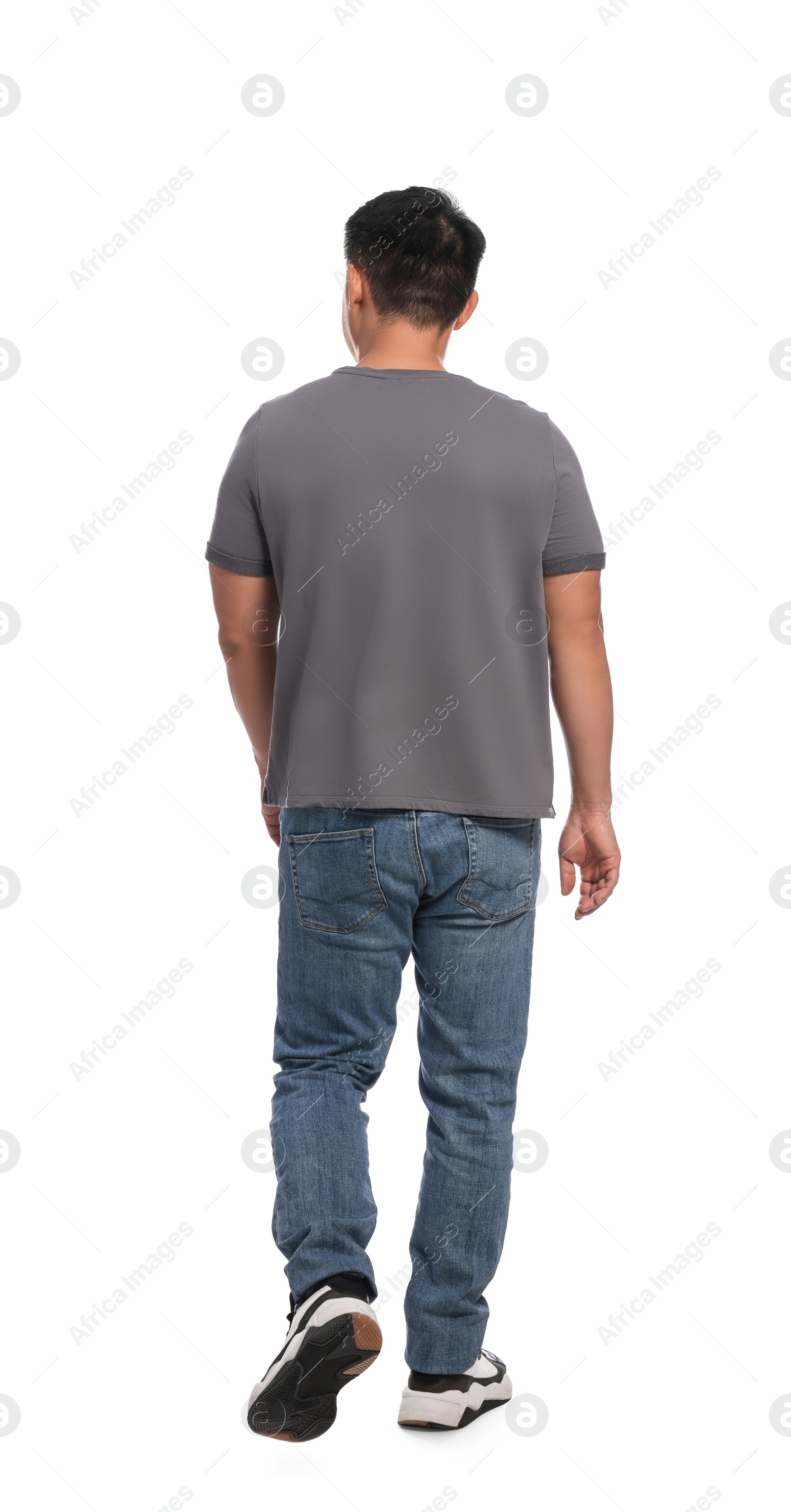 Photo of Man in casual outfit walking on white background, back view