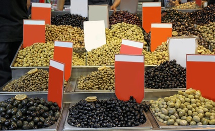 Assortment of tasty marinated olives at market