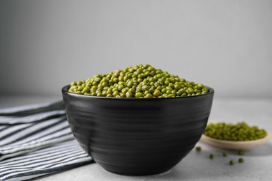 Photo of Bowl with green mung beans on grey table, closeup