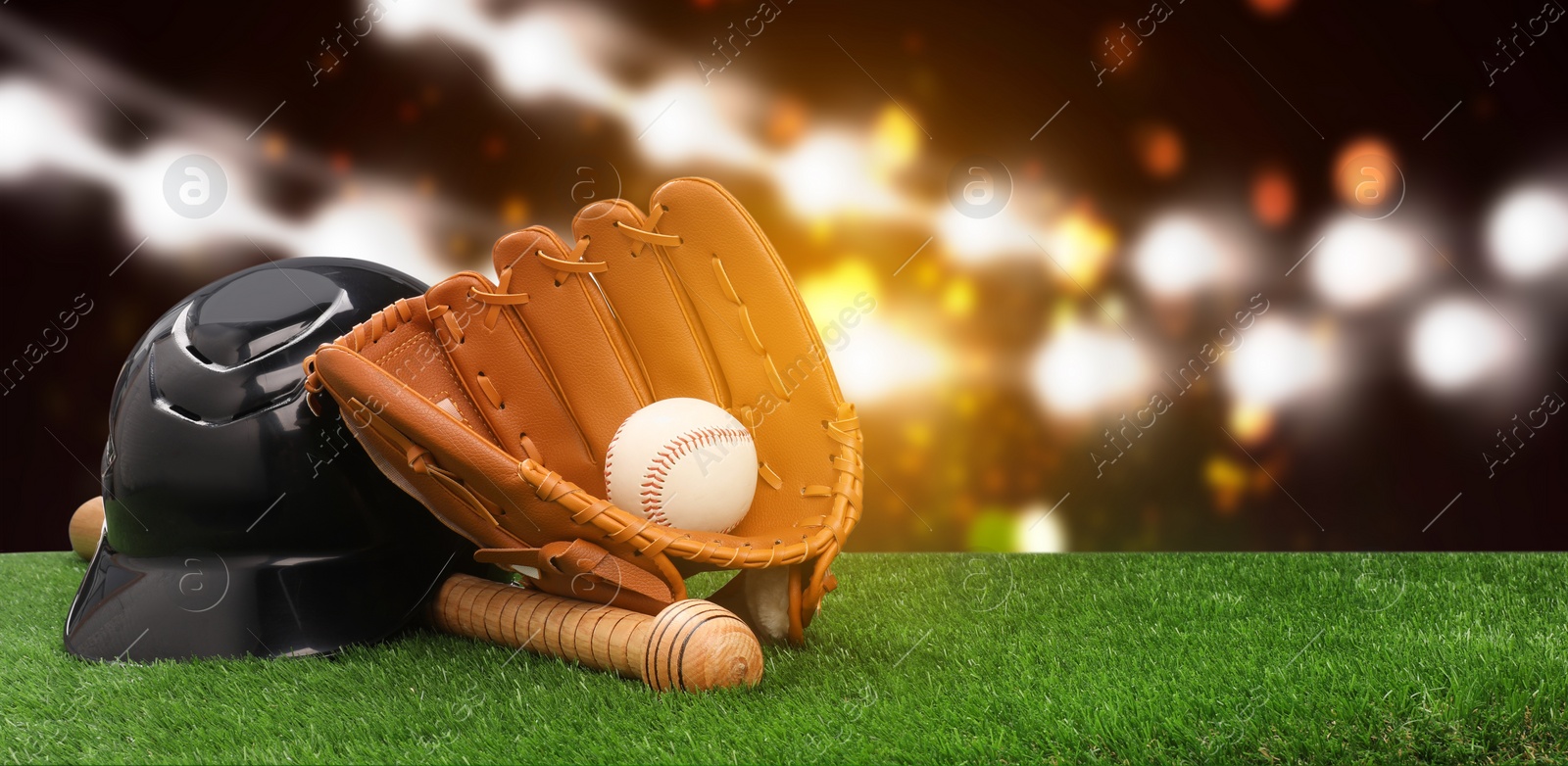 Image of Baseball bat, glove, helmet and ball on grass at stadium. Banner design with space for text