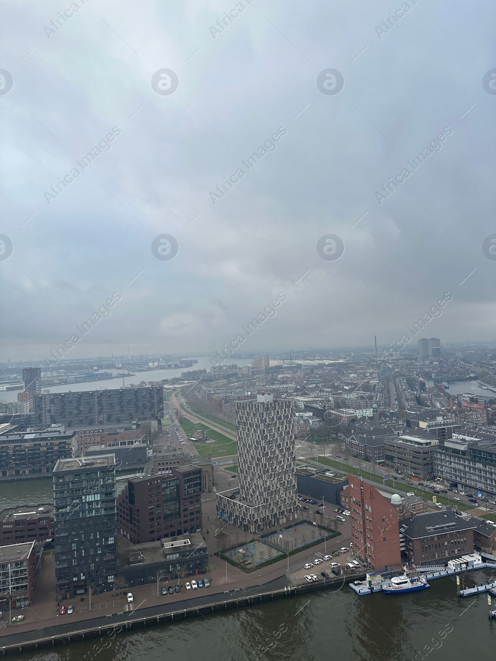 Photo of Picturesque view of city with modern buildings and harbor on cloudy day