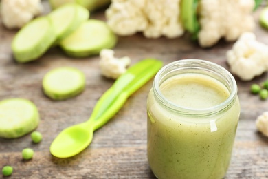 Jar with tasty baby food on table