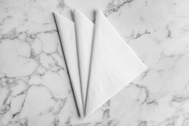 Photo of Folded clean paper tissues on white marble table, flat lay