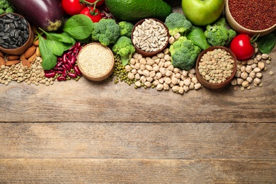 Different vegetables, seeds and fruits on wooden table, flat lay with space for text. Healthy diet