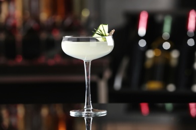 Photo of Glass of tasty cucumber martini on bar counter