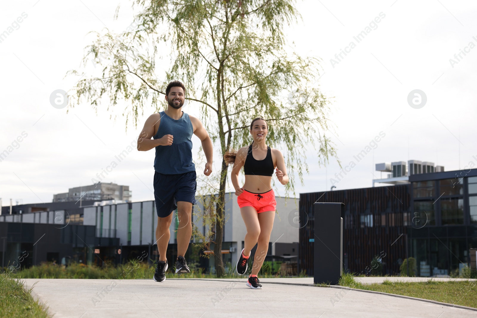 Photo of Healthy lifestyle. Happy couple running outdoors, space for text