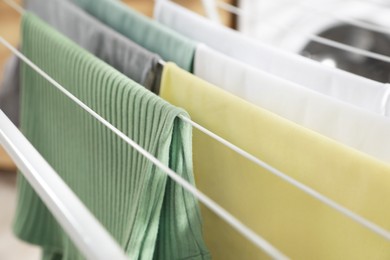 Photo of Different apparel drying on clothes airer, closeup
