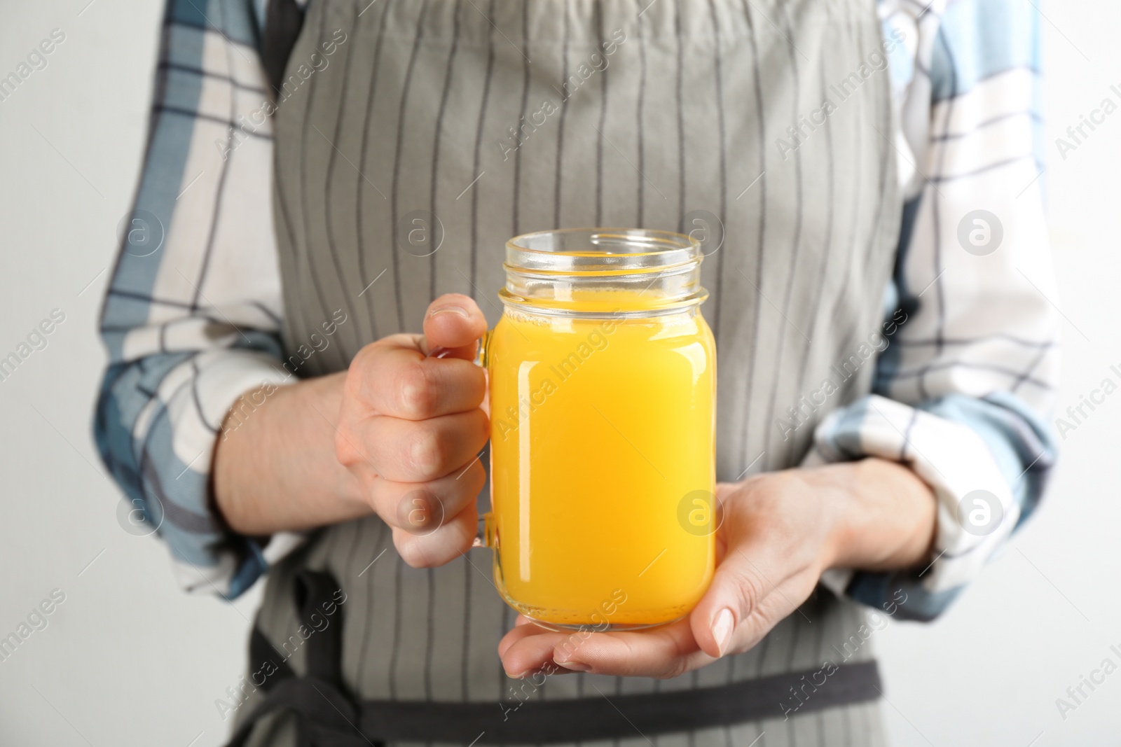 Photo of Woman holding mason jar of immunity boosting drink in hands, closeup