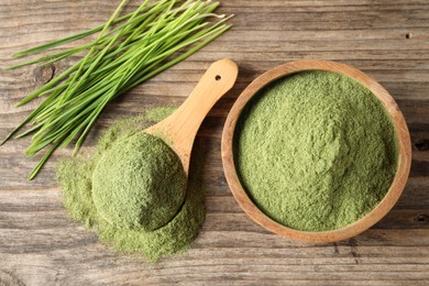 Photo of Wheat grass powder and fresh sprouts on wooden table, flat lay