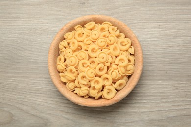 Photo of Raw dischi volanti pasta in bowl on light grey wooden table, top view