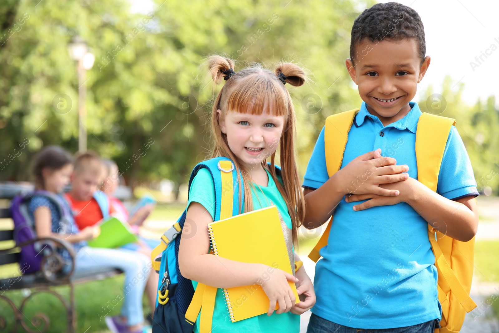 Photo of Cute little children with backpacks outdoors. Elementary school