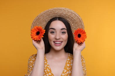 Beautiful woman with spring flowers in hands on yellow background