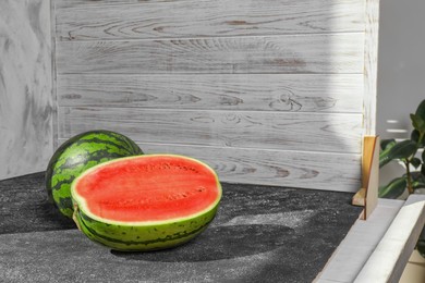 Photo of Fresh juicy watermelon and double-sided backdrops on table in photo studio. Space for text