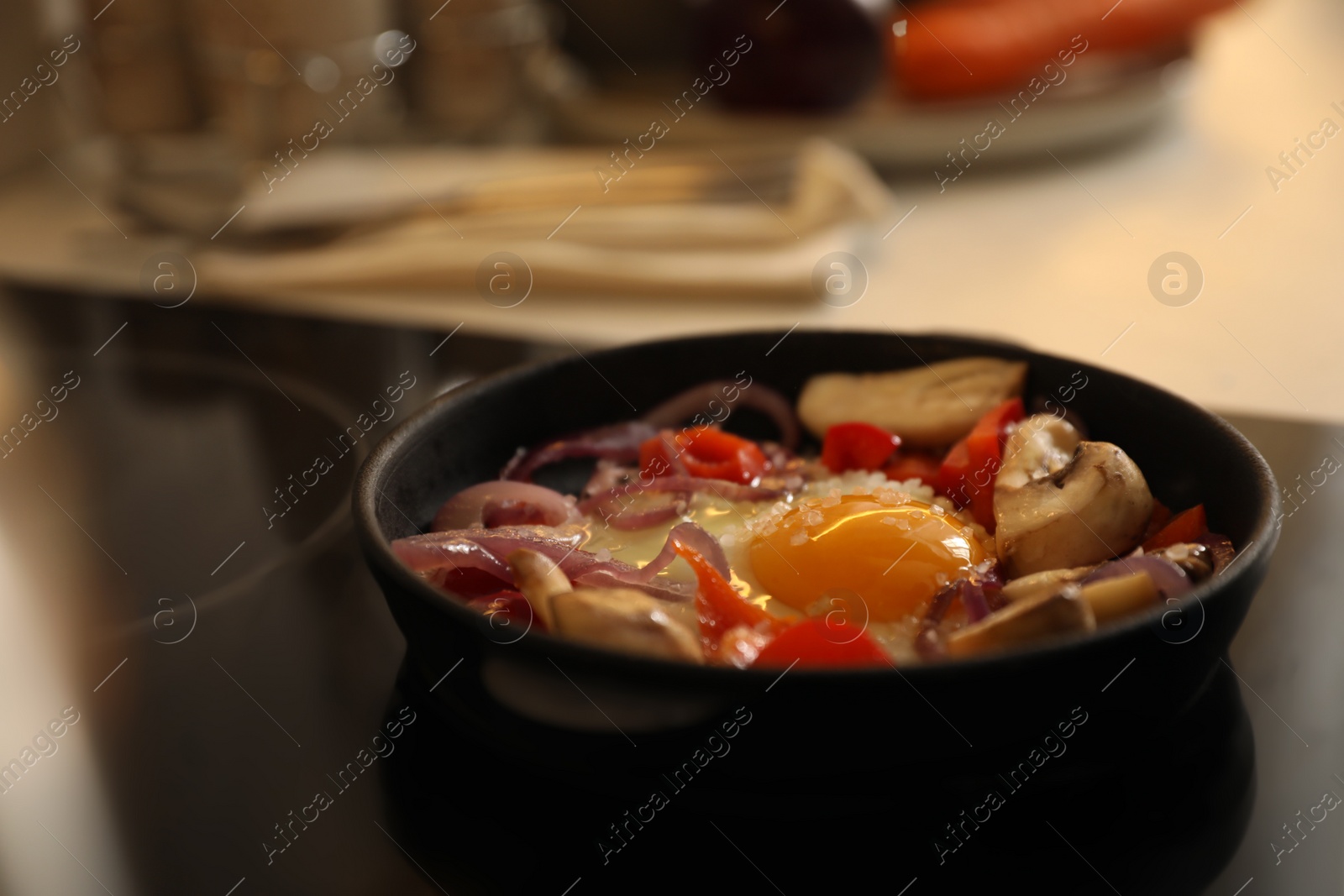 Photo of Frying pan with tasty egg and vegetables on stove, space for text