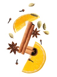 Cut orange and different spices falling on white background. Mulled wine ingredients