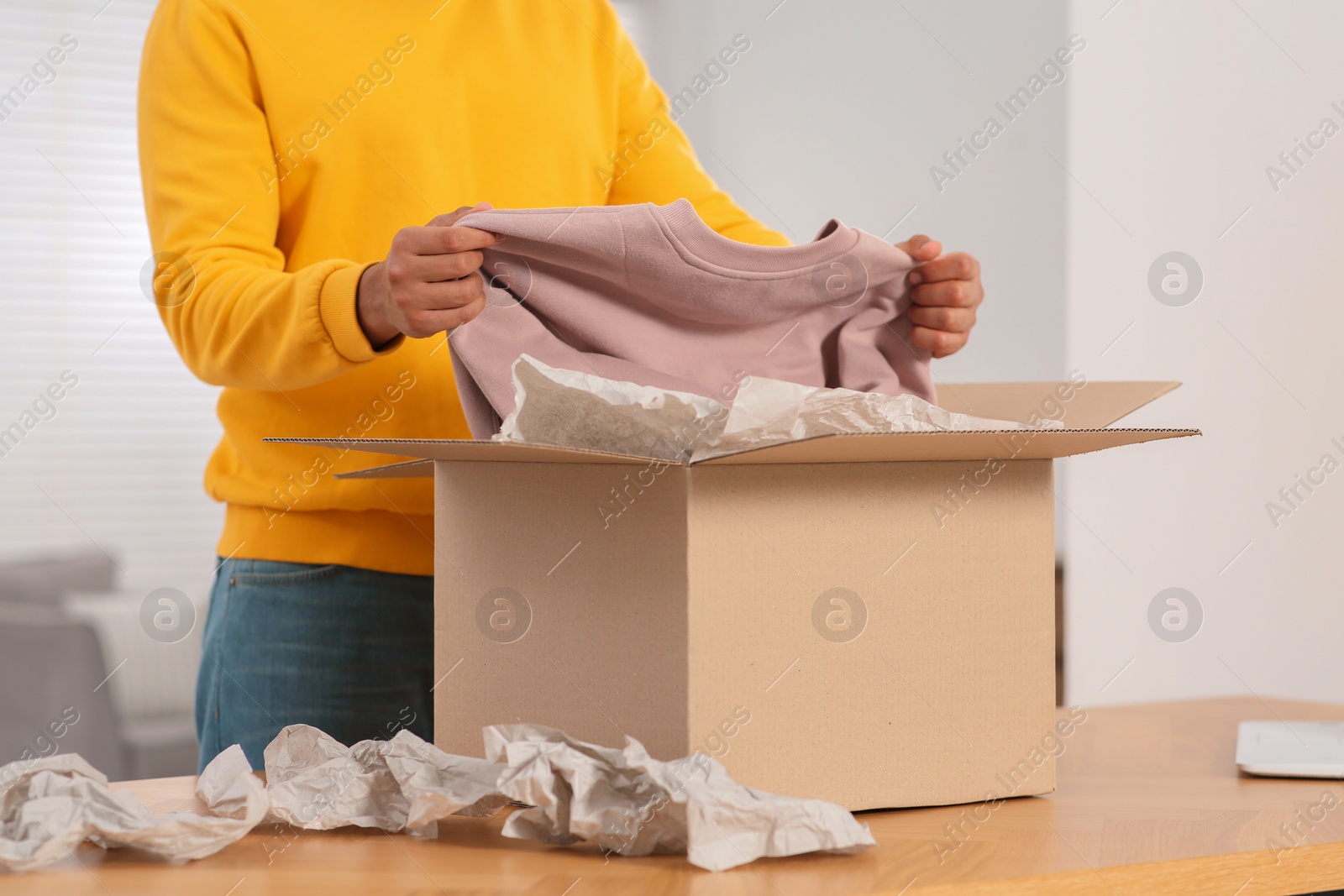 Photo of Young man opening parcel with Christmas gift, closeup