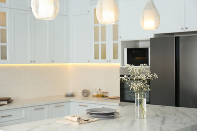 Photo of Beautiful plates and bouquet on table in kitchen