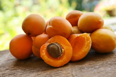 Delicious ripe apricots on wooden table outdoors, closeup