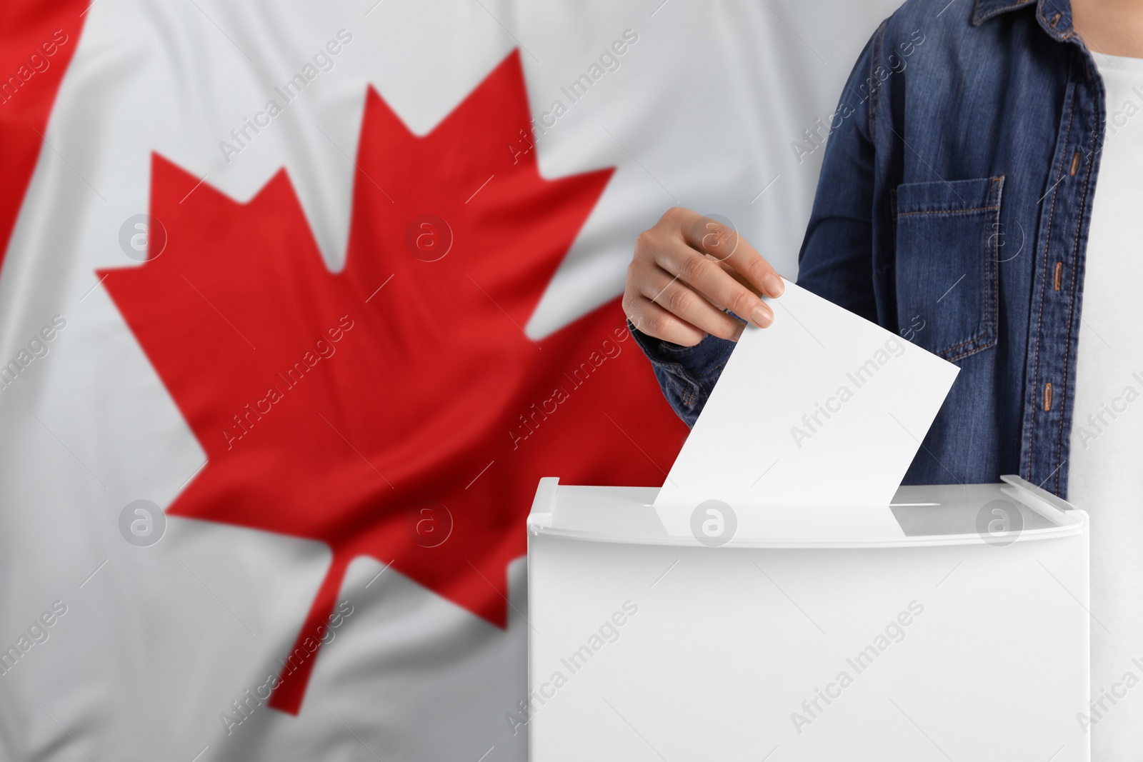 Image of Woman putting her vote into ballot box against national flag of Canada, closeup. Space for text