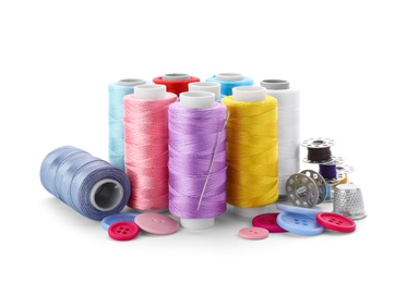 Color threads and sewing accessories on white background