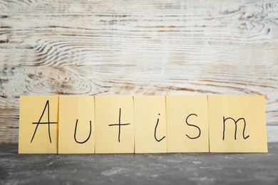 Notes with word "Autism" on table