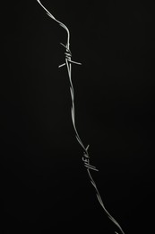 Photo of Shiny metal barbed wire on black background