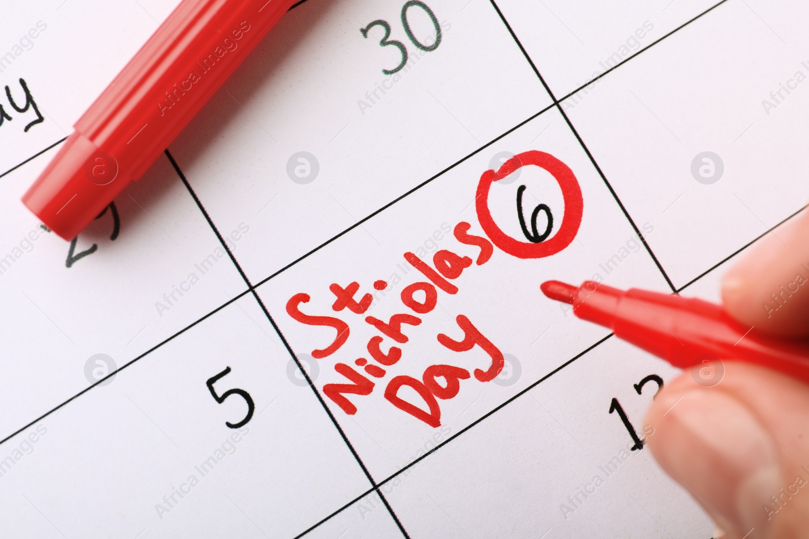 Photo of Woman marking date in calendar, closeup. December, 6 - Saint Nicholas Day