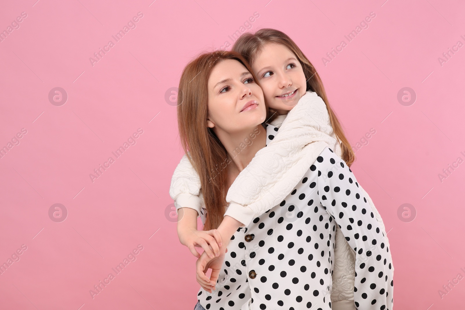 Photo of Portrait of mother and her cute daughter on pink background. Space for text