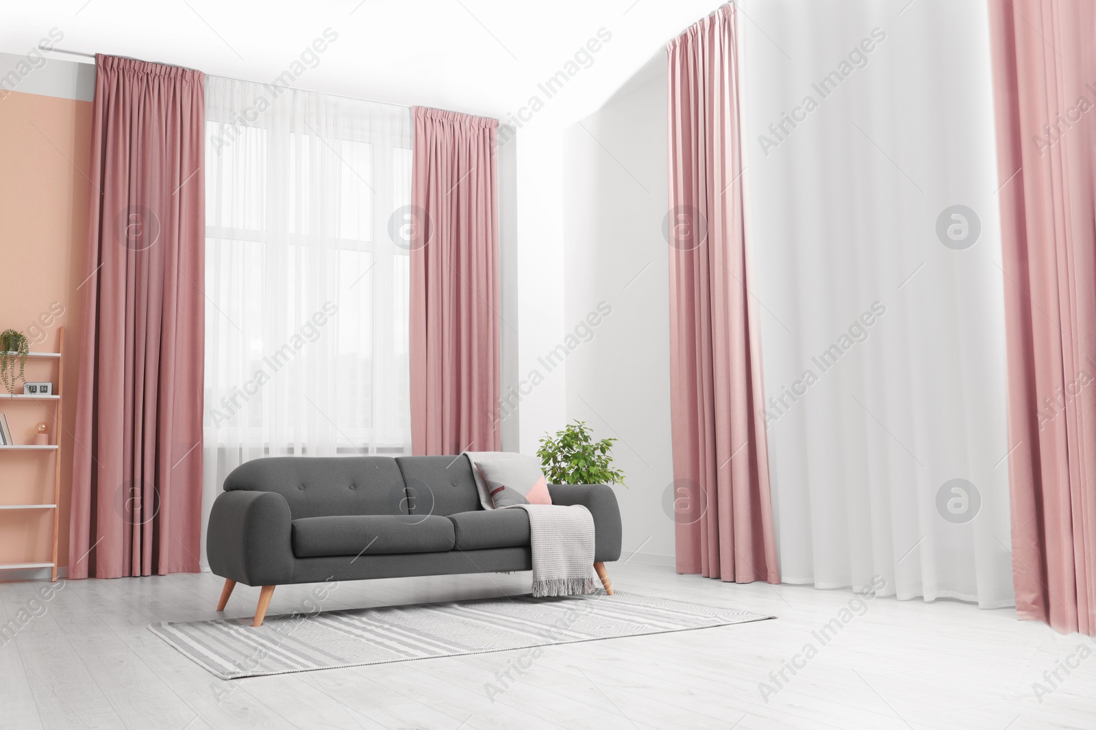 Photo of Stylish living room interior with cozy sofa, houseplant and elegant curtains