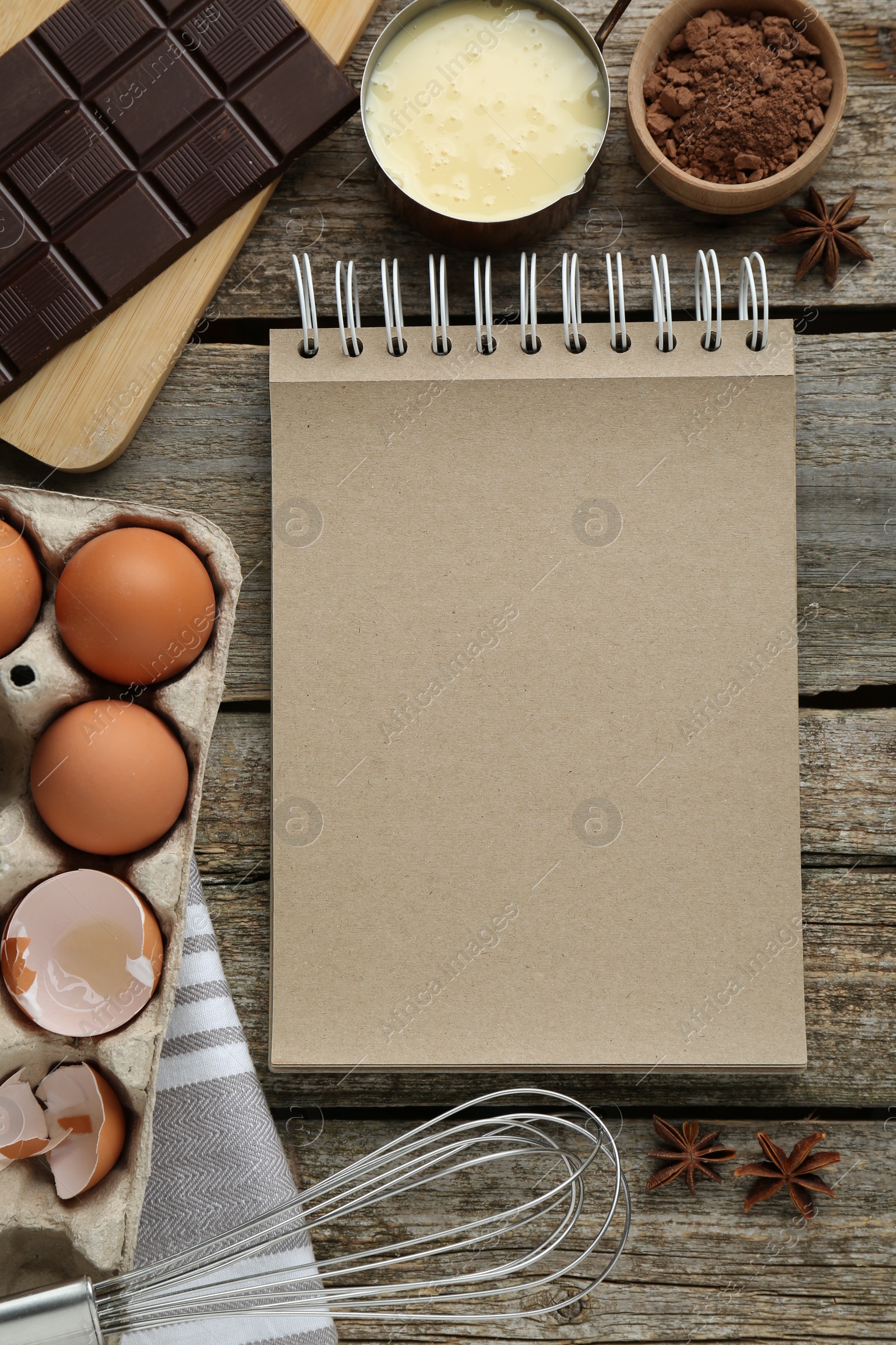 Photo of Blank recipe book and different ingredients on wooden table, flat lay. Space for text