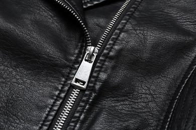 Photo of Closeup view of black leather jacket with zipper as background