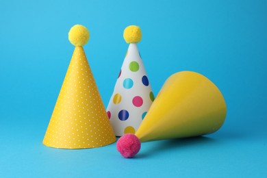 Photo of Colorful party hats on light blue background