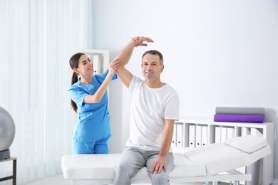 Photo of Doctor working with patient in hospital. Rehabilitation physiotherapy