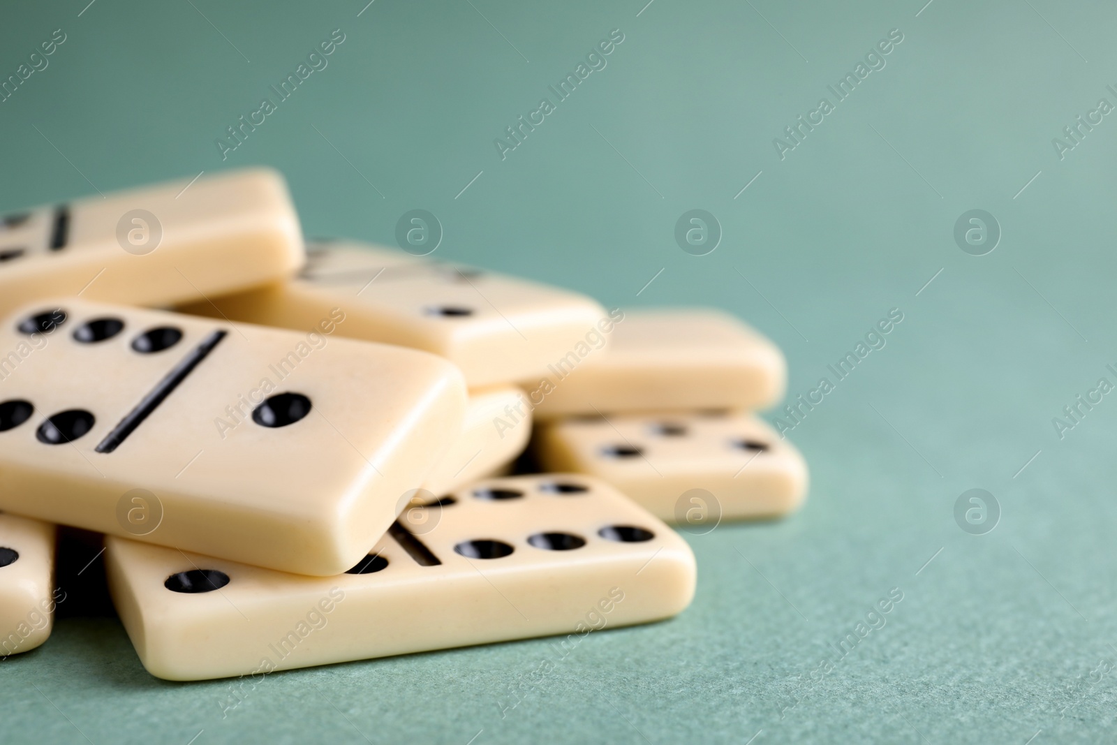 Photo of Classic domino tiles on grey background, closeup. Space for text