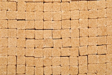 Photo of Brown sugar cubes as background, top view