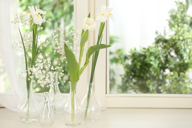 Photo of Beautiful fresh flowers on window sill indoors. Space for text