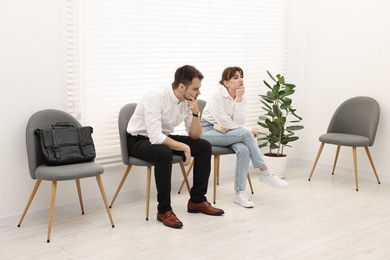 Man and woman waiting for job interview indoors