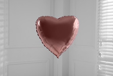 Photo of Festive heart shaped balloon in light room