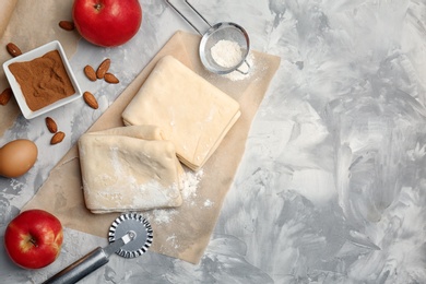 Photo of Flat lay composition with raw flaky dough and ingredients on table