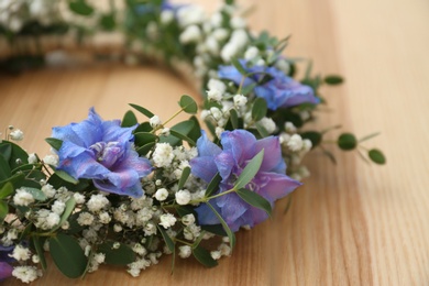 Photo of Beautiful flower wreath on wooden background, closeup