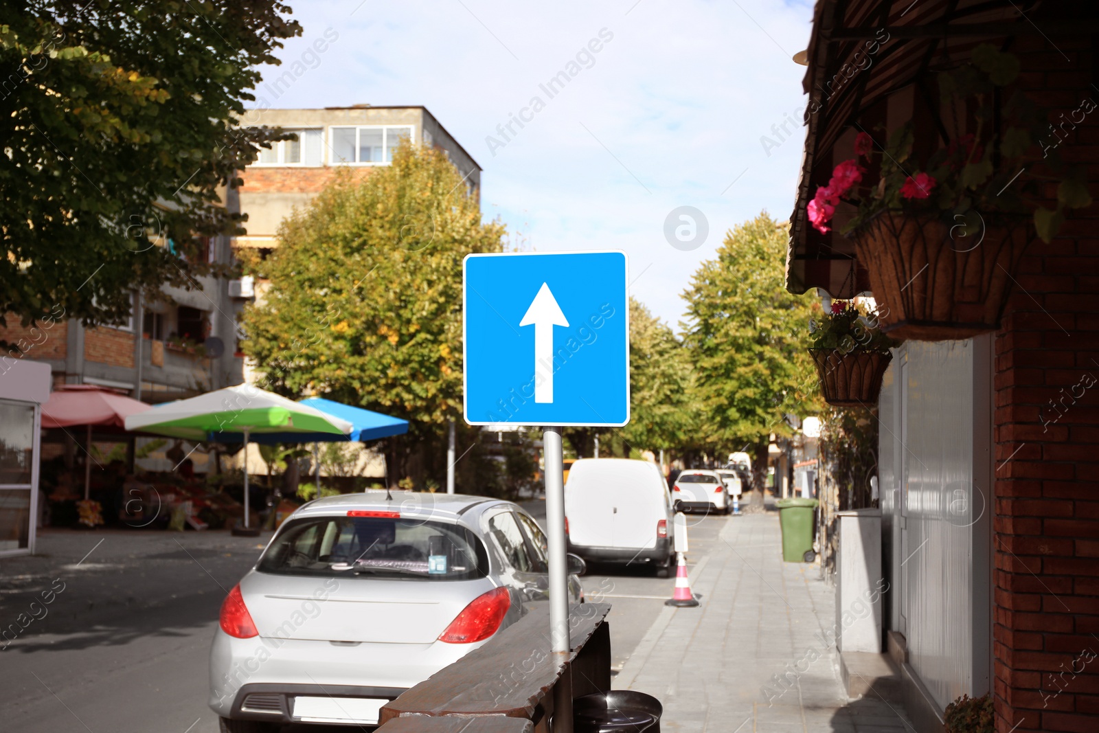 Photo of One Way Traffic sign near road with cars outdoors
