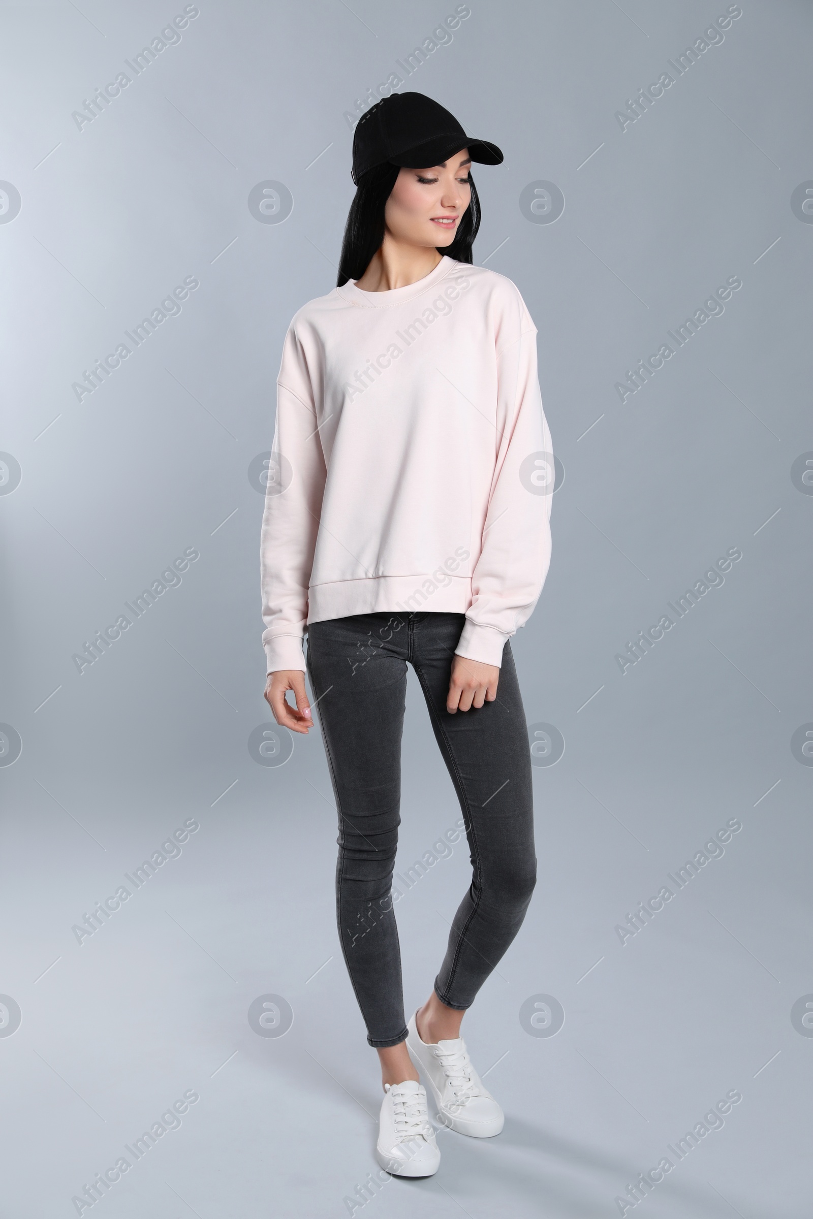 Photo of Full length portrait of young woman in sweater on grey background. Mock up for design