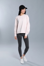 Full length portrait of young woman in sweater on grey background. Mock up for design