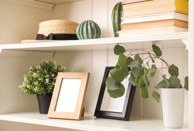 White shelving unit with plants and different decorative stuff