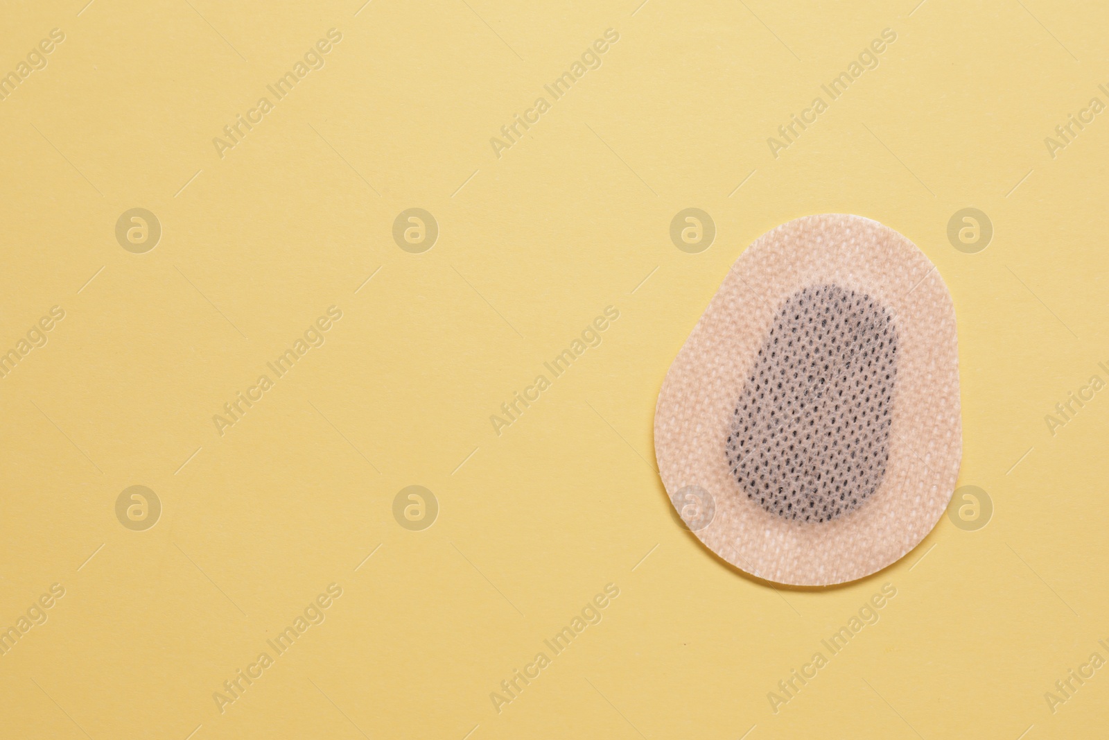 Photo of Contraceptive patch on yellow background, top view. Space for text