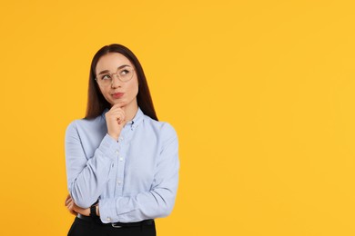 Photo of Curious woman wearing glasses on orange background, space for text