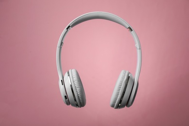 Photo of Wireless headphones with earmuffs on color background